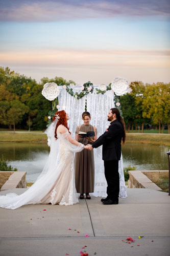 Lakeside wedding ceremony with floral arch - Kansas City wedding photographer