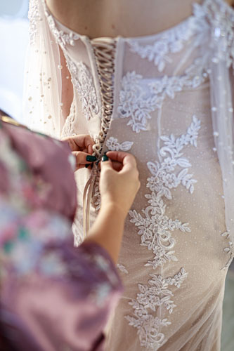 Getting ready - lacing wedding dress - Kansas City wedding photographer